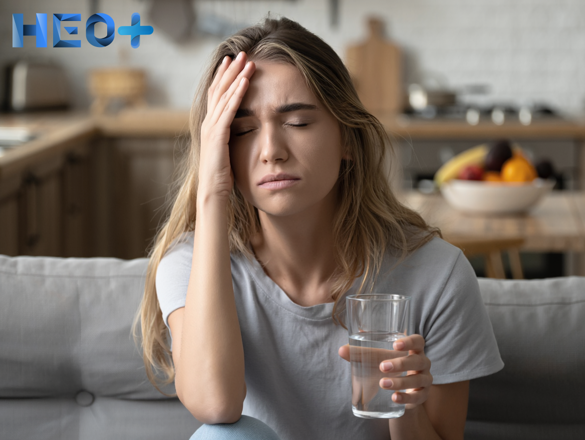 Женщина с головной болью сидит на диване