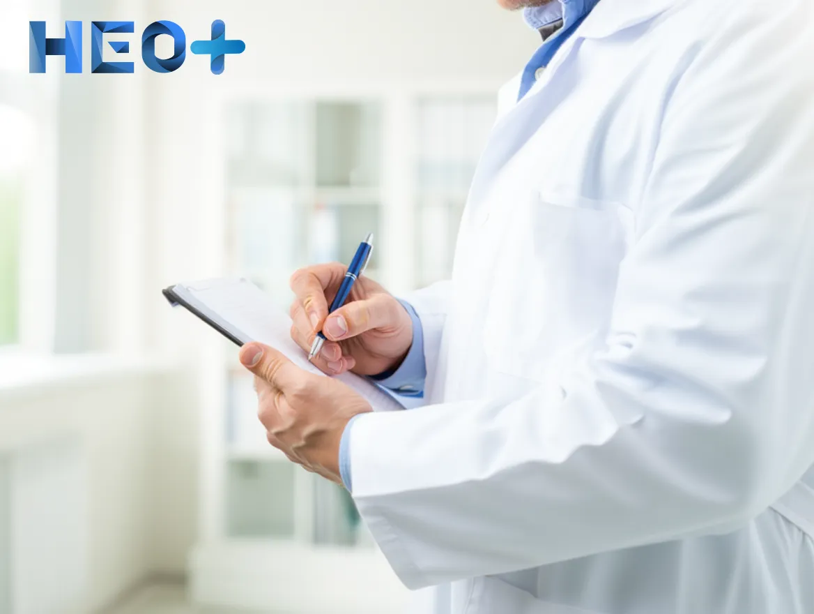 Врач сидит за столом и записывает что-то в блокнот